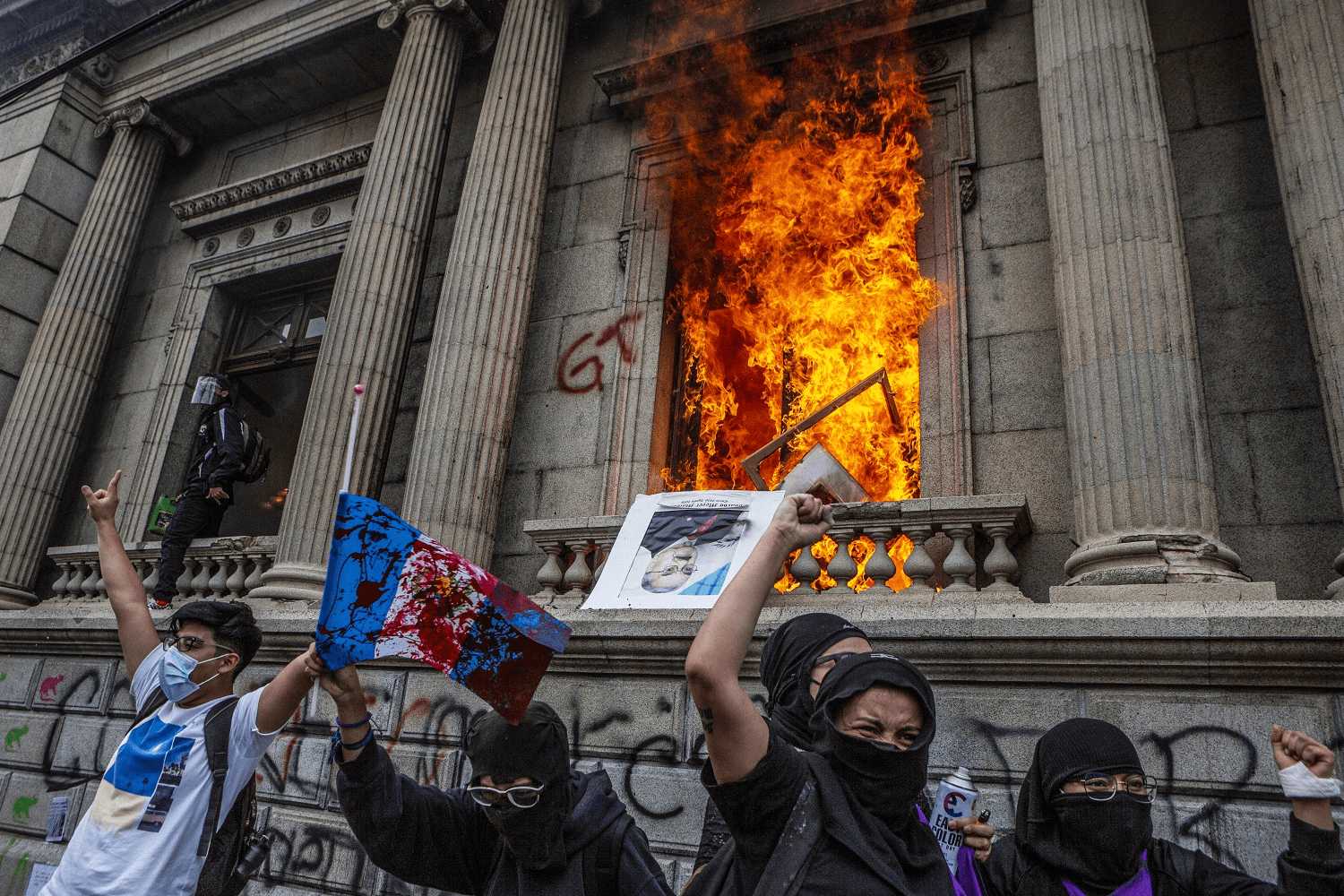 Varios manifestantes vitorean frente al Congreso de la República tras romper ventanas y prender parte del mobiliario que se encontraba dentro del recinto el 21 de noviembre de 2020. | Foto: Oliver de Ros